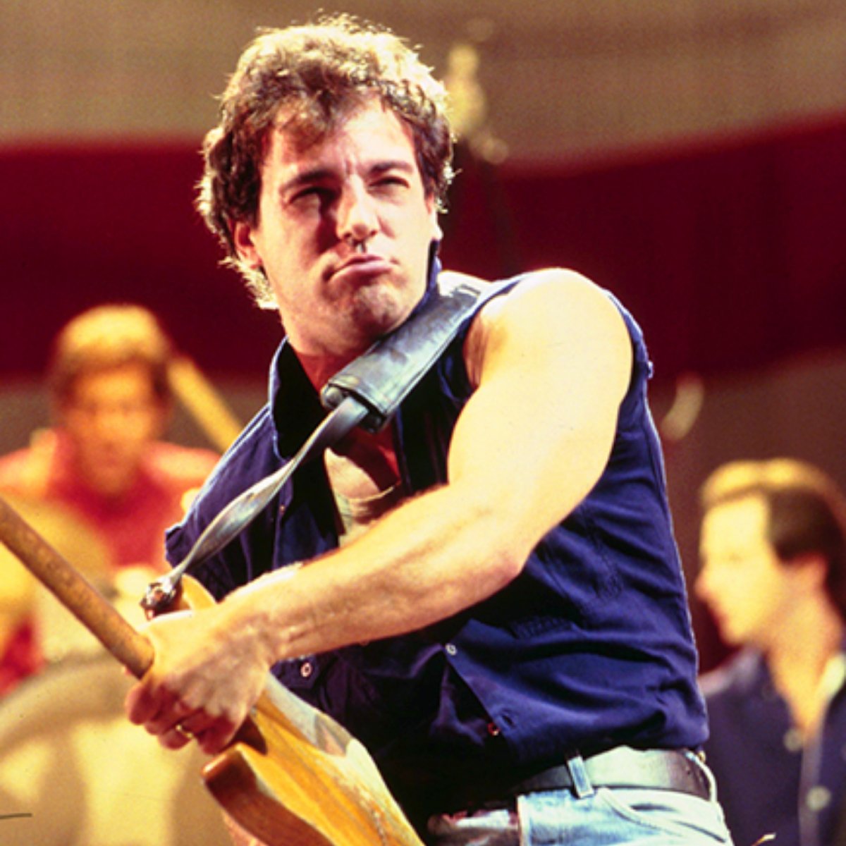 Bruce Springsteen playing guitar on stage circa 1980s